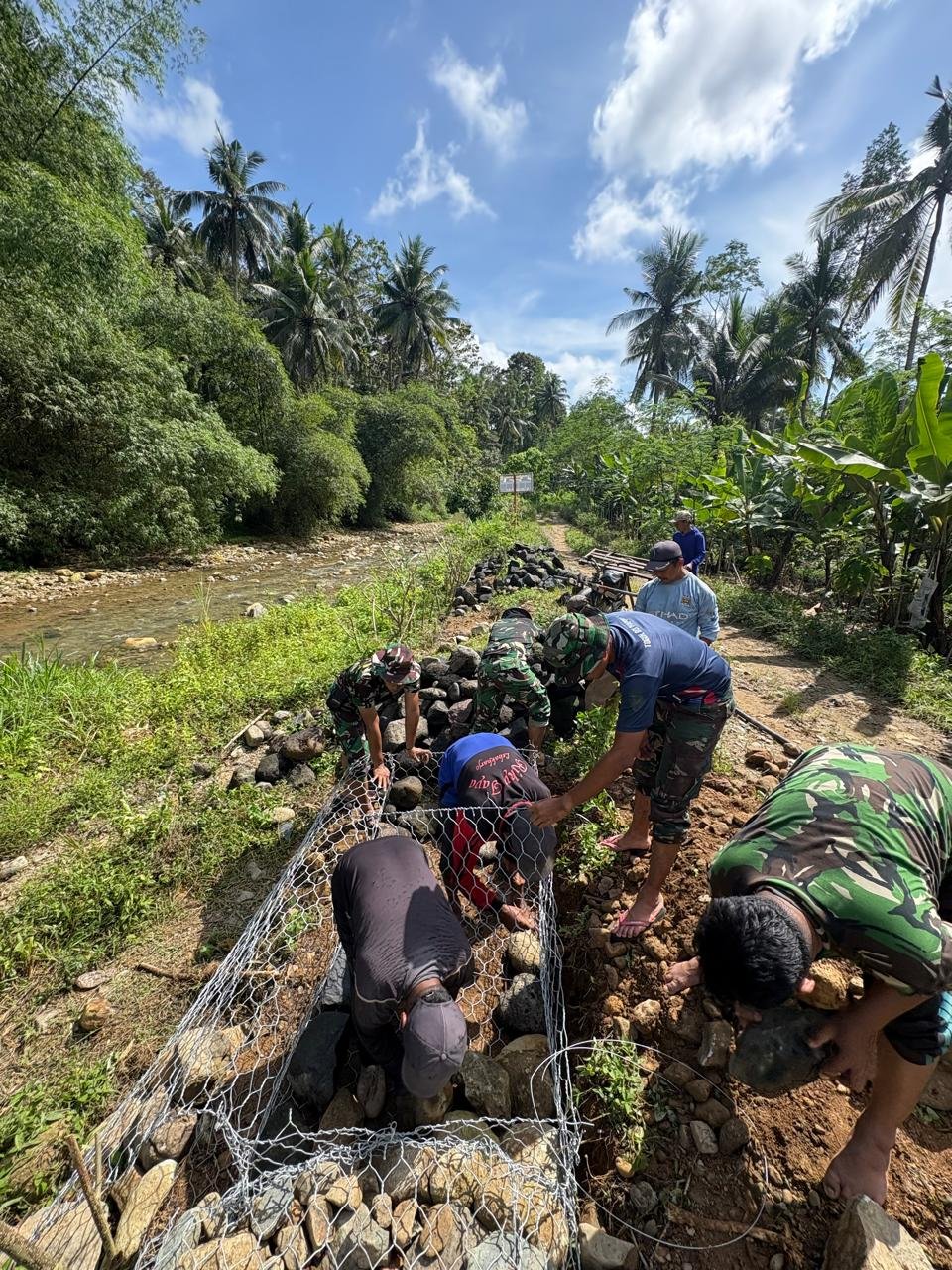 Anggota Satuan Tugas TNI Manunggal Membangun Desa (TMMD) ke-126 Kodim 0818/Malang-Batu yang berasal dari AURI terus melanjutkan pekerjaan pemasangan bronjong batu di Dusun Sukomaju B, Desa Lebakharjo
