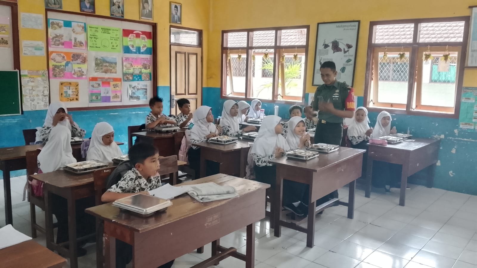 Hari Pertama Masuk Sekolah, Sertu Rachmad Abadi Dampingi Penyaluran Makan Bergizi Gratis di Desa Dadapan