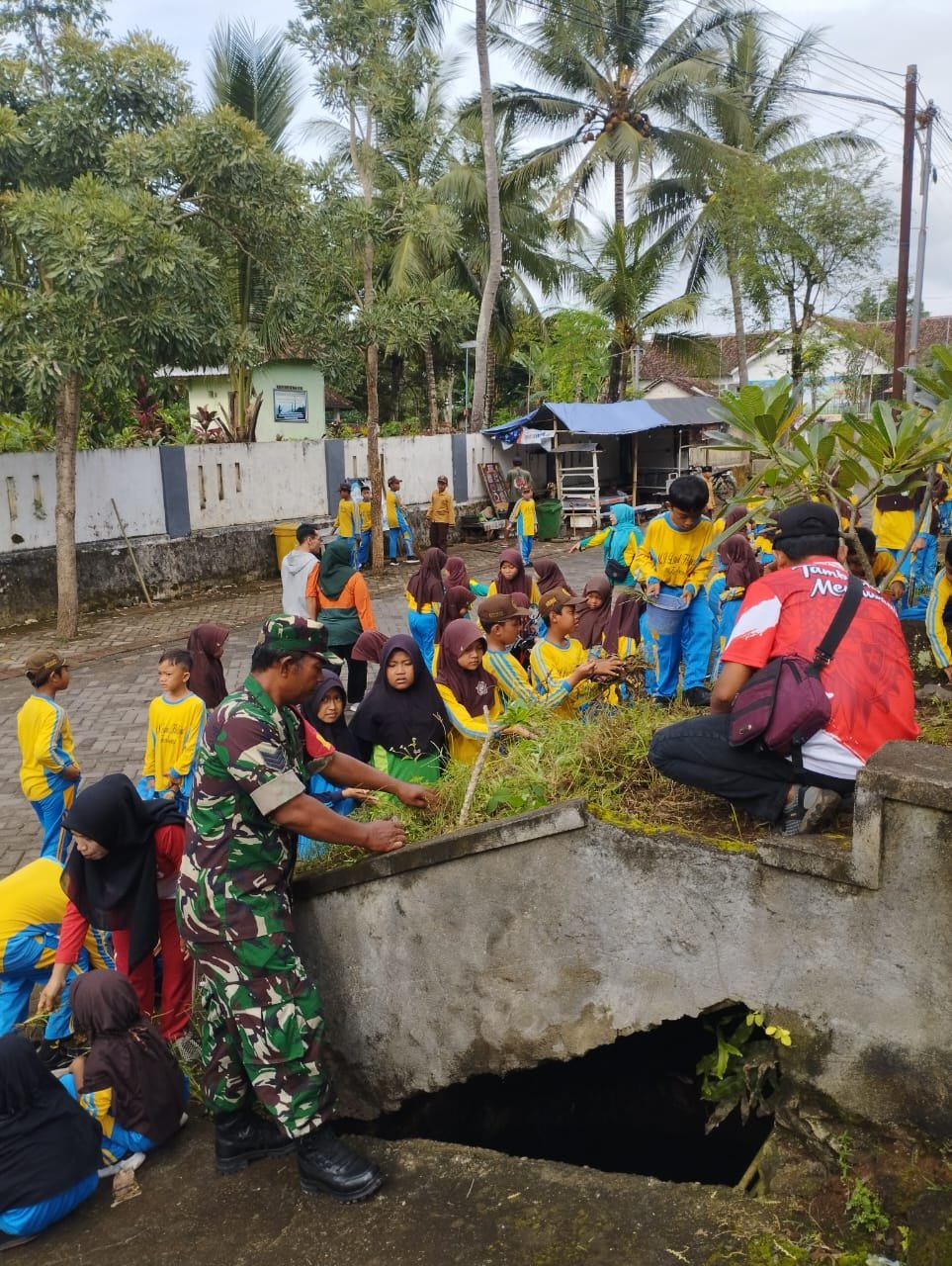 Babinsa Tambong Beri Motivasi Anak Sekolah dalam Karya Bakti di RTH Desa